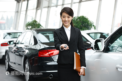 青年女人機動車站著汽車銷售人員